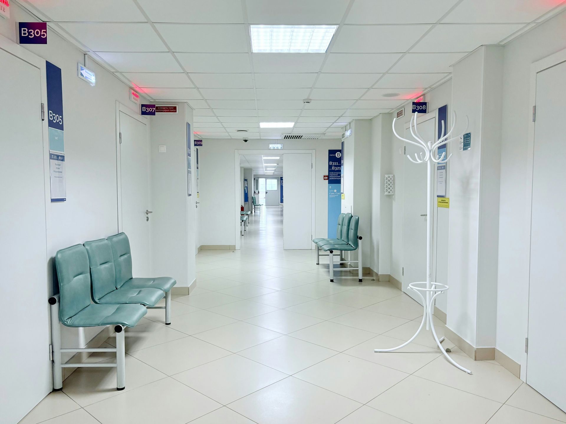 Empty hospital corridor with benches and doors
